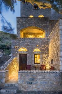 a stone house with lights on the side of it at Porto Kale Guesthouse in Porto Kagio