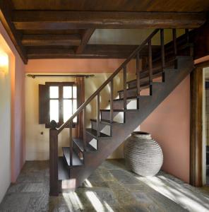 a wooden staircase in a room with a vase at Porto Kale Guesthouse in Porto Kagio