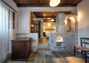 a stone fireplace in a room with a bedroom at Porto Kale Guesthouse in Porto Kagio