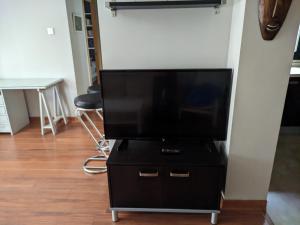 a flat screen tv sitting on a black dresser at Casa del Doctor in Seville