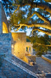 a painting of a building with a tree at Porto Kale Guesthouse in Porto Kagio