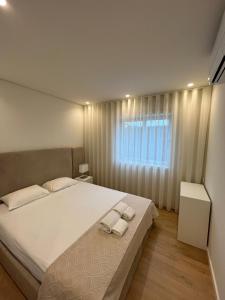 a bedroom with a large bed with two towels on it at Brittos Home Lovely Stay - Villa Prime in VN de Famalicão Braga in Vila Nova de Famalicão