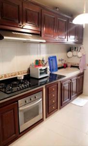 a kitchen with wooden cabinets and a stove top oven at Bel appartement à Casablanca 2 chambres in Casablanca