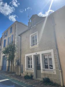 a building on a street with the sun shining on it at La Har'Elle in Château-Gontier