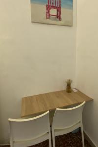einen Holztisch mit zwei Stühlen und ein Gemälde an der Wand in der Unterkunft Casa Zaguan in Cartagena de Indias