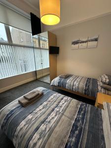 um quarto com 2 camas e uma grande janela em Hayfield Apartment em Oban