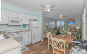 a kitchen and living room with a table and a dining room at Salty Dogs - Gated, Private Dock, Beach Access in Myrtle Beach