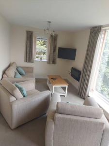 Sala de estar con 2 sofás y mesa en Otterhole Barn Holiday Apartment, en Buxton