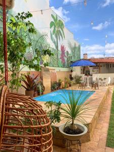 une terrasse avec une piscine ornée de plantes et une fresque murale. dans l'établissement POUSADA CAPIM LIMÃO, à Diamantina