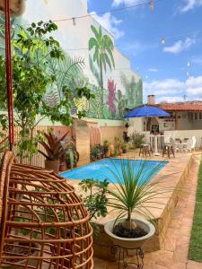 a patio with a pool with plants and a mural at POUSADA CAPIM LIMÃO in Diamantina