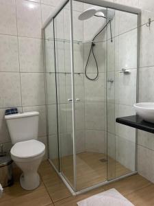 a bathroom with a shower with a toilet and a sink at Residencial da Cris in Florianópolis