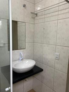 a bathroom with a sink and a mirror at Residencial da Cris in Florianópolis