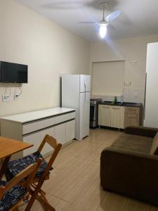 a living room with a white refrigerator and a table at Residencial da Cris in Florianópolis