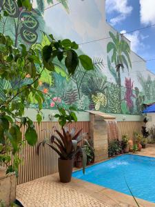 una piscina con un mural en el lateral de un edificio en POUSADA CAPIM LIMÃO, en Diamantina