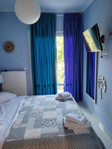 アギオス・イオアニス・ペリオンにあるCentaur Villaのベッドルーム1室(青い壁のベッド1台、窓付)