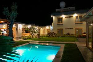 a swimming pool in front of a house at night at Acari Adventure & ski Resort in Acarí