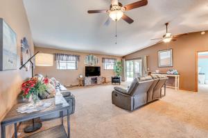 a living room with couches and a ceiling fan at Kissimmee Home with Private Pool, 18 Mi to Disney! in Kissimmee