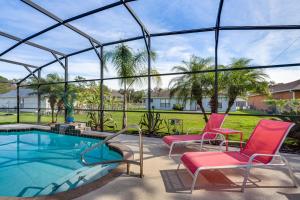 a patio with two chairs and a swimming pool at Kissimmee Home with Private Pool, 18 Mi to Disney! in Kissimmee