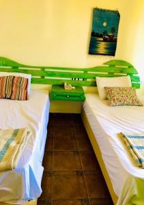 two twin beds in a room with a green headboard at Luxury Chalet - La Hacienda in Ras Sedr