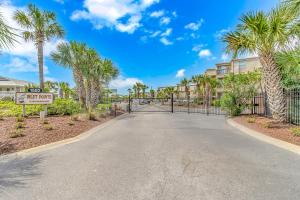 a gate at the end of a driveway with palm trees at Fishing Dock, Trailer Parking, Gated, Beach Access in Myrtle Beach