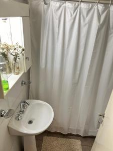 a bathroom with a white shower curtain and a sink at The best experience and service in Mendoza
