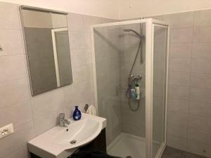 a white bathroom with a shower and a sink at Villa Mazzano in Riva del Garda