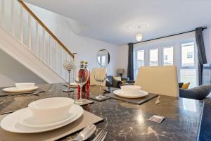a dining room with a table with plates and wine glasses at Luxury Birmingham City Centre Townhouse with FREE Parking - Sleeps 4 - Perfect for Contractors, Business Travellers, Families and other Groups - Near Bullring, Newstreet, Selfridges, NEC, NIA & Birmingham airport in Birmingham