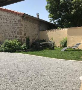 un tavolo e sedie in un cortile accanto a un edificio di Jolie maison de campagne, Compostelle a Soleymieux
