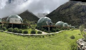 un grupo de cúpulas en un campo con una montaña en Sky Lodge Domes Salkantay en Soray