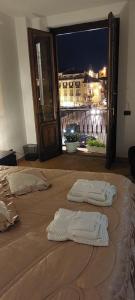 2 weiße Handtücher auf einem Bett mit Stadtblick in der Unterkunft Casa Santa Lucia in Cosenza