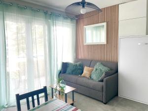 a living room with a couch and a table at Caprozion-Erosoa-T1-Piscine-Clim in Ciboure +14 photos