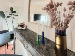 a table with two candles and a vase with flowers at Logement au coeur de Marseille, le Stassi in Marseille