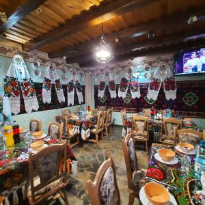 a dining room with tables and chairs and a tv at Pensiunea Codrea - Wagner in Lazu Baciului