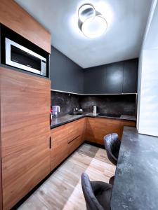 a kitchen with black cabinets and a table with chairs at Cozy Retreat Apartment in Ventspils