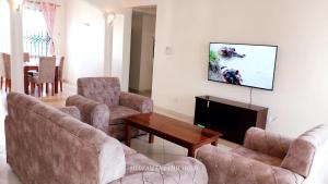 een woonkamer met banken en een flatscreen-tv bij Two Bedroom Nyali, City Mall in Mombasa