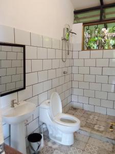 a bathroom with a toilet and a sink at Almendra de Montaña in Puerto Viejo
