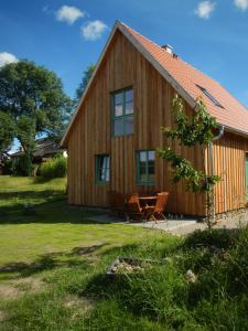 une maison en bois avec une table et des chaises devant elle dans l'établissement Ferienlandhaus Zempow, à Zempow