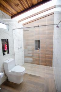 a bathroom with a toilet and a glass shower at Glamping Monteverde San gil in San Gil