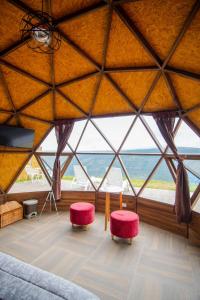 een kamer met een groot raam met een bed en 2 stoelen bij Glamping Monteverde San gil in San Gil