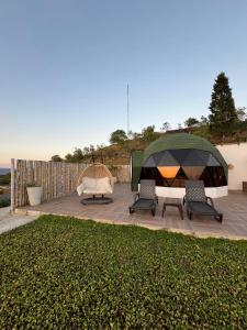 um gazebo com 2 cadeiras e uma tenda em Glamping Monteverde San gil em San Gil