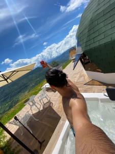a man standing in the water in a swimming pool at Glamping Monteverde San gil in San Gil