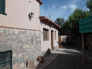 un edificio blanco con una pared de piedra y una ventana en Lo de Lili en Tilcara