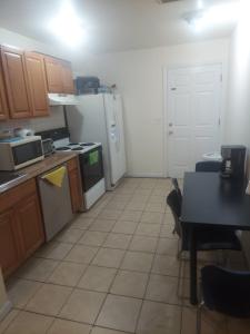 a kitchen with a white refrigerator and a table with a table at Crystal Room 1 Guest House near 12mins to EWR airport / Prudential / NJIT / Penn station in Newark