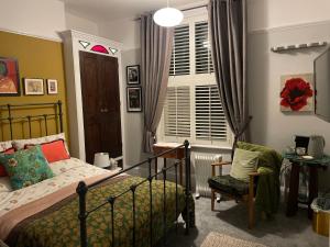 樸次茅斯的住宿－The green house，卧室配有床、椅子和窗户。