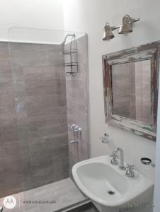 ein Badezimmer mit Waschbecken und Dusche mit Spiegel in der Unterkunft Casa Gutiérrez in Godoy Cruz