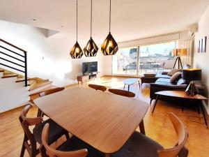 - un salon avec une table et des chaises en bois dans l'établissement Casa con vistas al mar en Premià de Dalt Barcelona, à Premia de Dalt