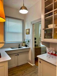 cocina con fregadero y barra con copas de vino en Large Elegant Home Walk to BROWN RISD, en Providence