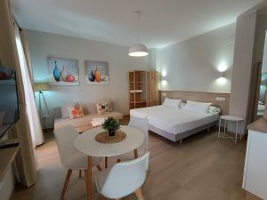 a room with a bed and a table and a couch at Apartamentos turísticos CASA de los BALCONES in Chipiona +70 photos