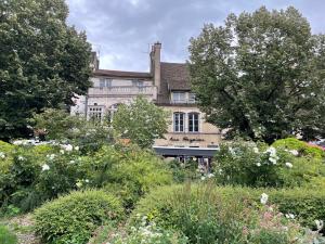 una casa antigua con un jardín delante de ella en Le jardin des Vérottes, en Beaune