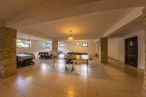 a dining room with ping pong tables in a room at Poiana Soarelui in Moieciu de Sus +25 photos